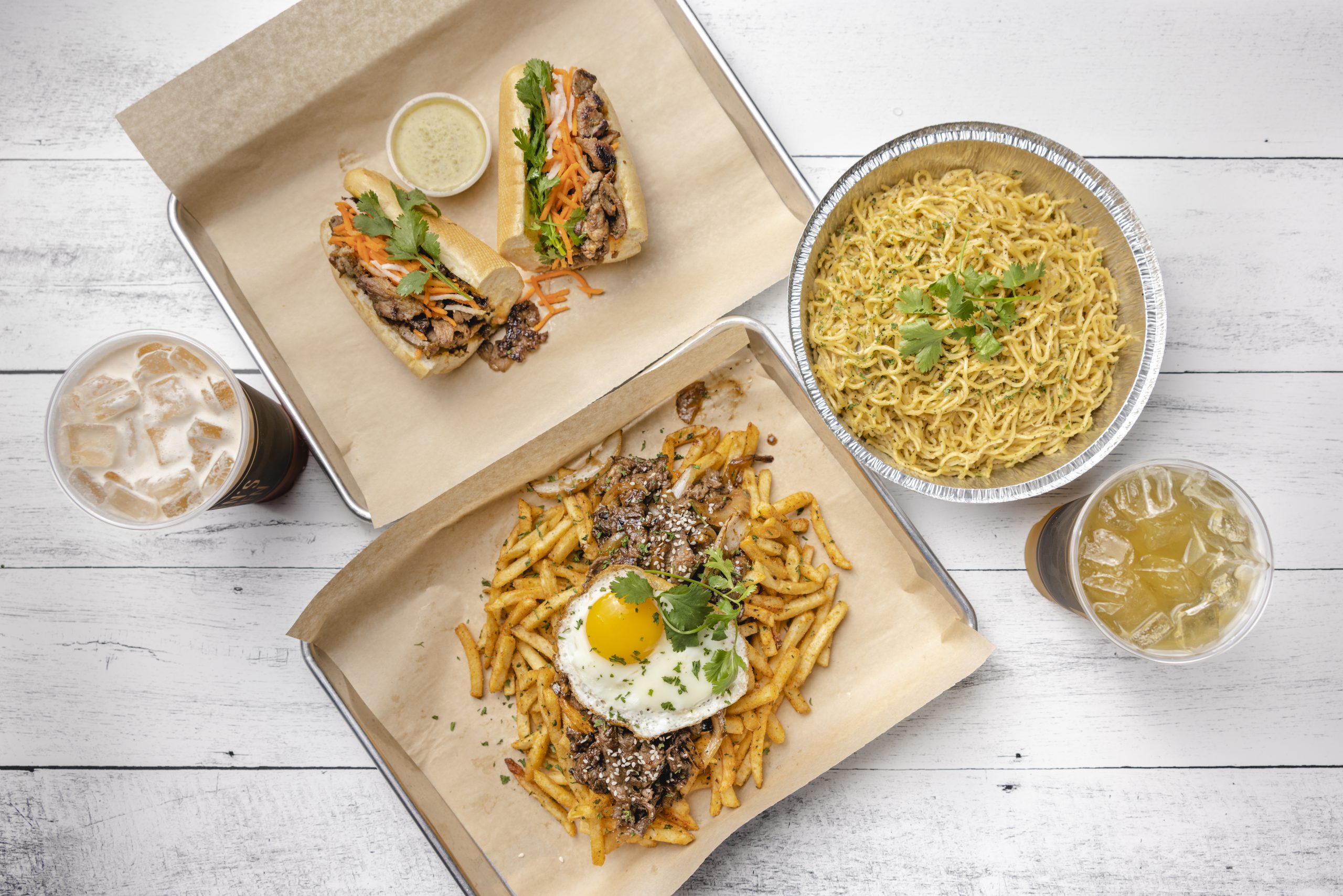 Nguyen's Kitchen sandwiches, garlic noodles, seasoned fries, and iced drinks